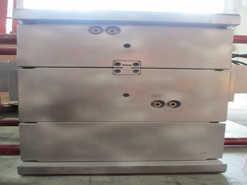 Ejector pins inside an injection mold used to remove a finished plastic part from the mold cavity