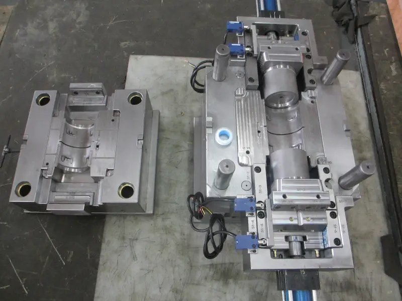 Close-up of injection molded plastic parts showing vacuum bubble defects caused by shrinkage and insufficient packing.