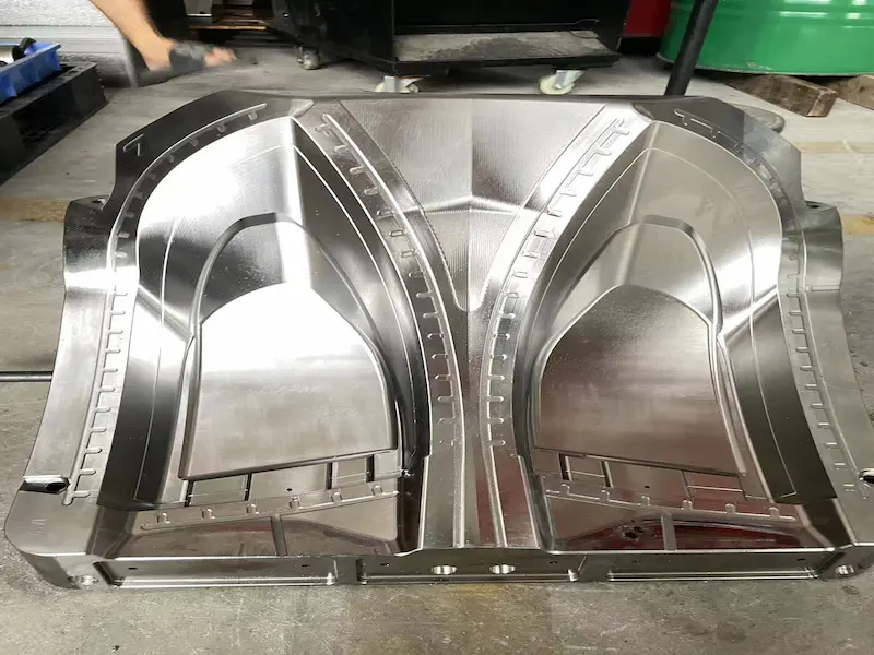 Precision mold polishing process showing polished cavity surface, steel quality inspection, and manual finishing work