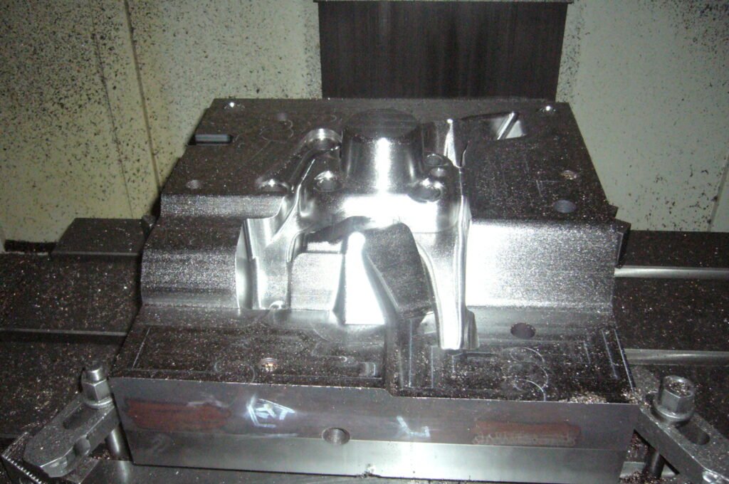 Technician grinding and polishing a precision mold cavity using oil stones and polishing tools