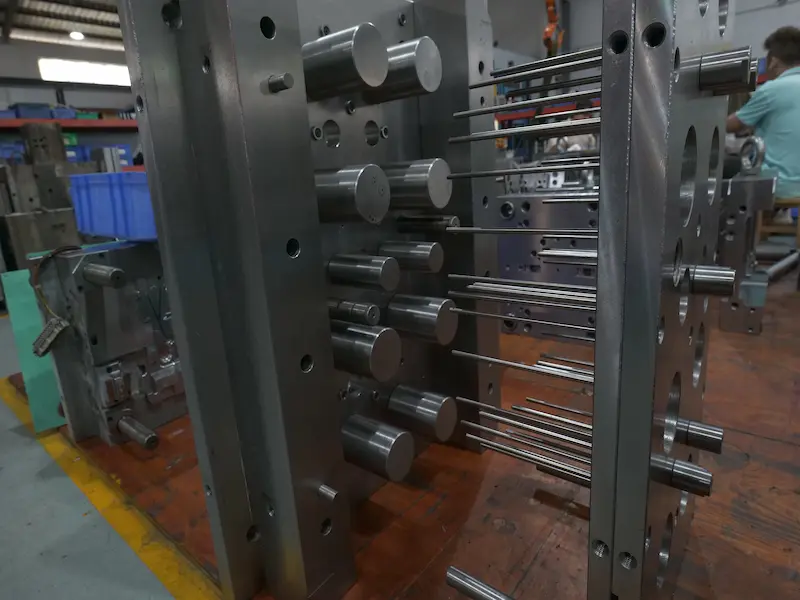 Plastic injection mold structure showing parting surface, sliders, guide pillars, and gating system