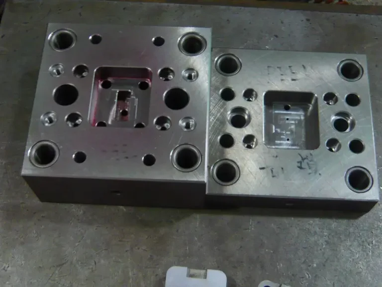 Close-up of an injection molded plastic part showing gate blush, radial flow streaks, and surface discoloration around the point gate.