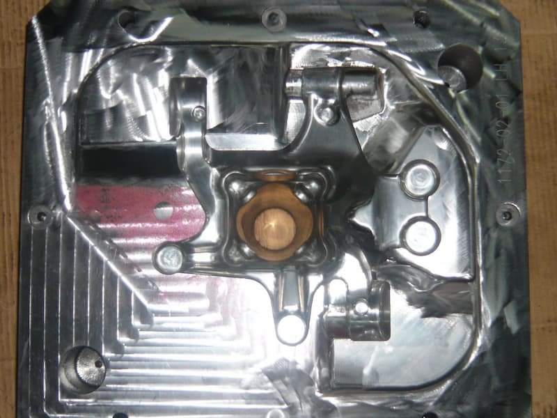 Polished injection mold cavity with complex contours, rib features, and precision-machined surfaces for producing a detailed plastic component.