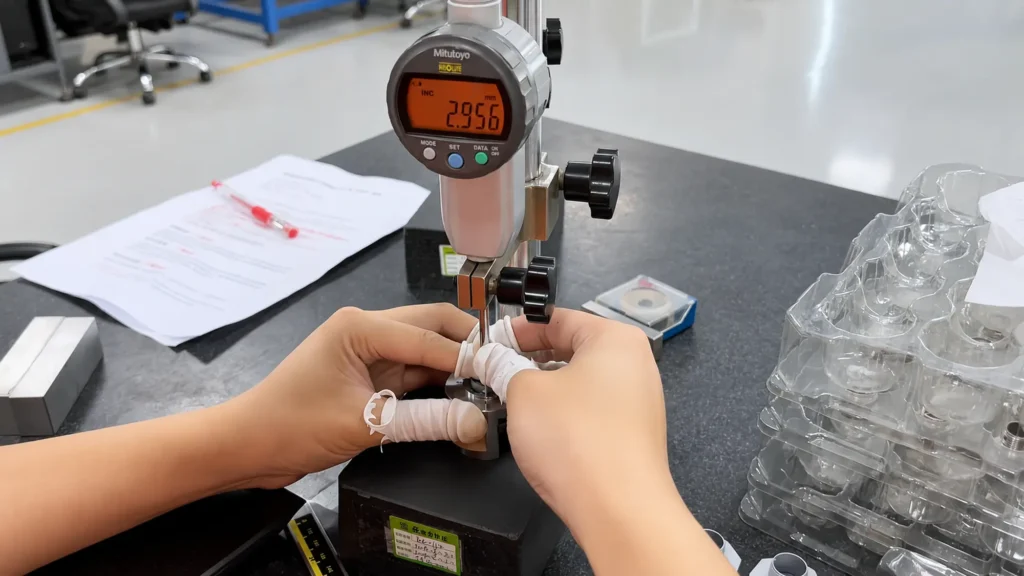 Inspector measuring the height of a precision metal casting with a digital indicator
