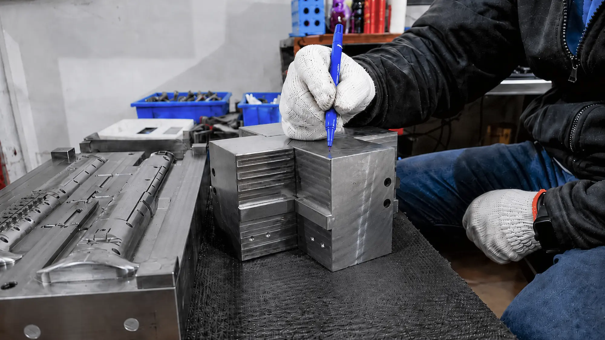Toolmaker marking machining areas on mold steel before precision mold manufacturing