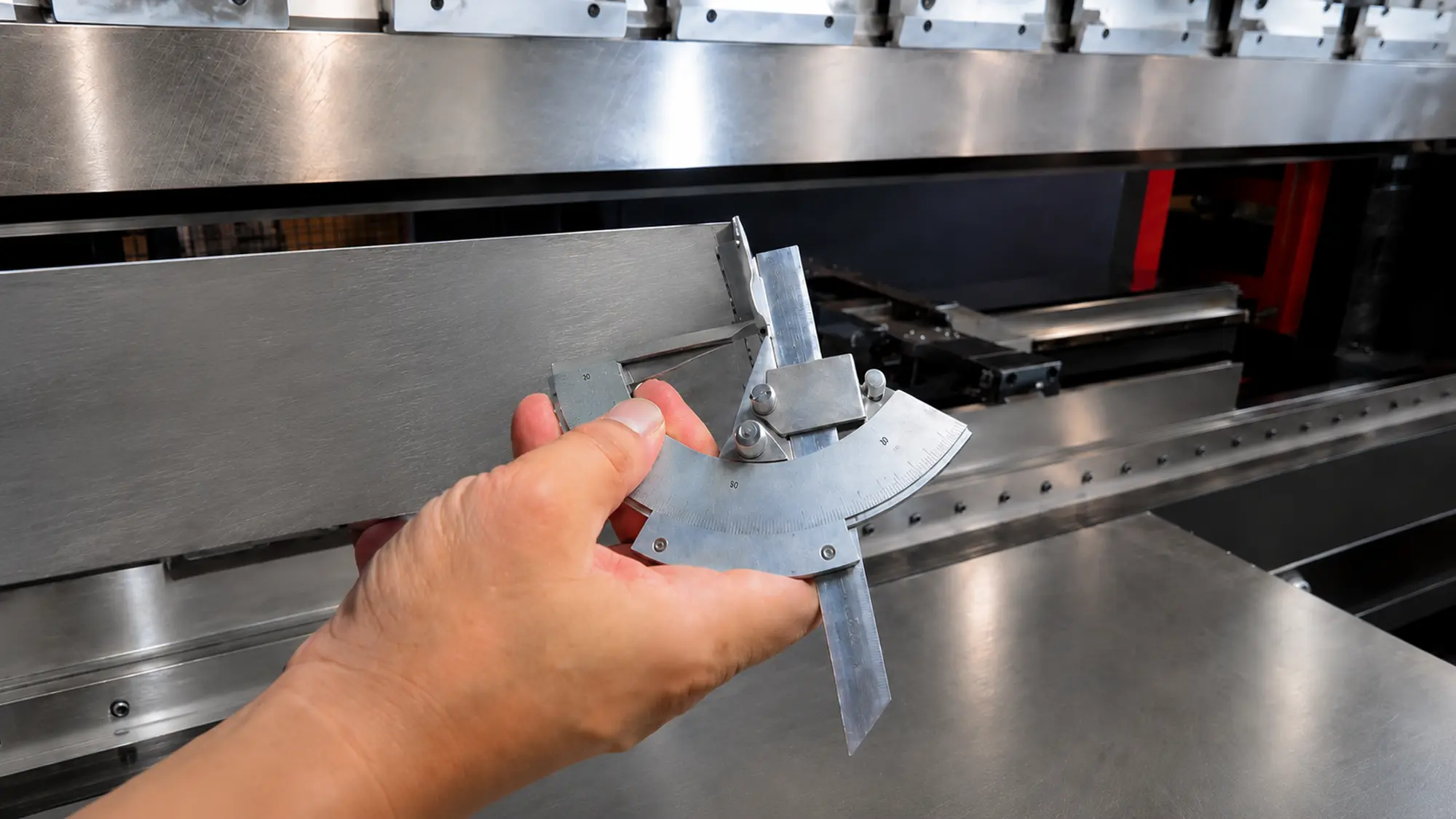 Engineer inspecting a low-volume sheet metal prototype for dimensions, bend accuracy, and assembly fit