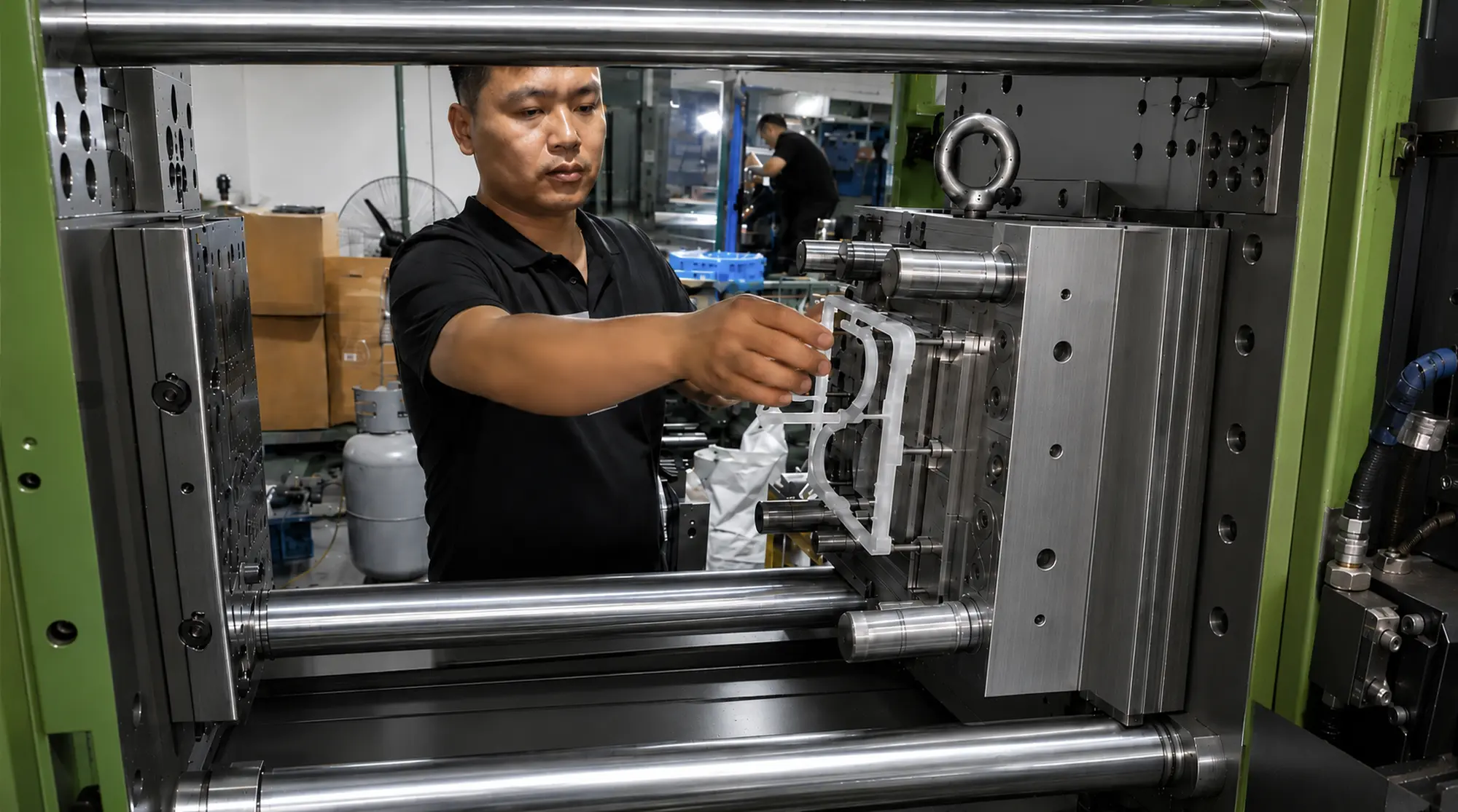 Toolmaker removing the first molded part during a T0 injection mold trial