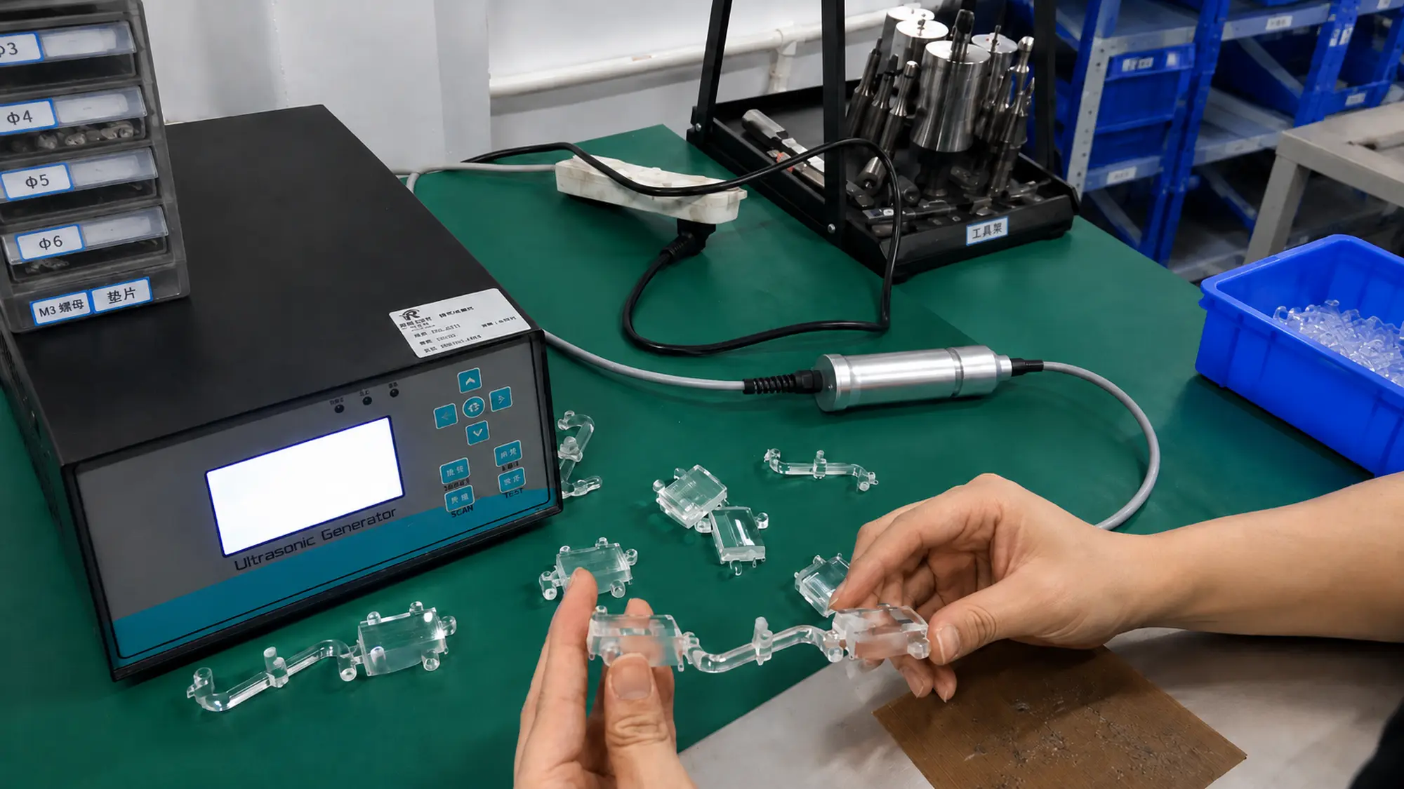 Operator inspecting transparent injection molded parts after ultrasonic cleaning for surface cleanliness and visual quality